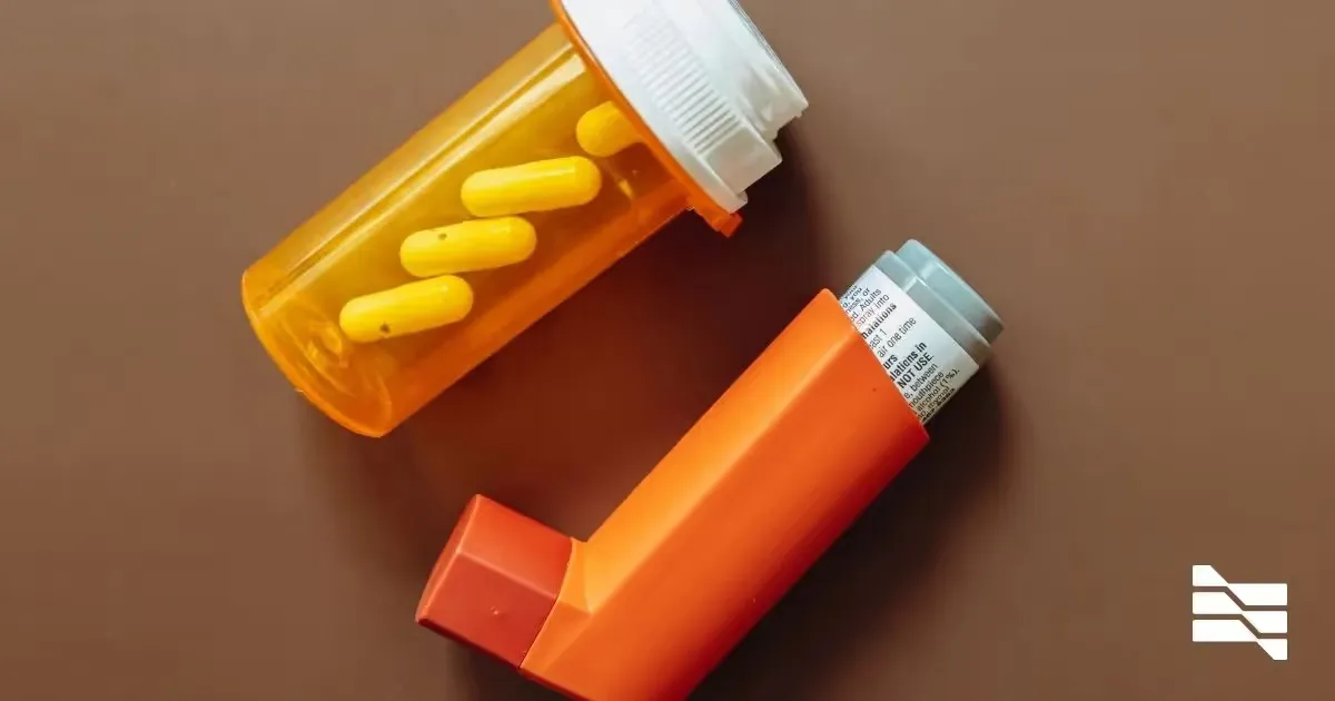 Overhead view of an asthma inhaler and a bottle of yellow capsules, illustrating healthcare and medical treatment management.